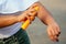 Hands of a dark-skinned woman close up holding a bottle of sunscreen spray applying spf cream on arms and shoulders on a