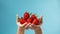 hands delicately holding strawberries with ultra-realistic details, set against a bright color background, and composed