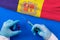 Hands of doctor holding syringe and coronavirus COVID-19 vial vaccine on flag Andorra