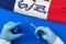 Hands of doctor holding syringe and coronavirus COVID-19 vial vaccine on flag Iowa