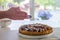 Hands dusting a colorful fig tart with icing sugar in the kitchen