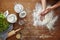 Hands dusting off flour baking scene flour on wooden table