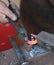 Hands of an elderly blacksmith working iron with a hammer and th