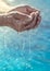 Hands of an elderly man holding sea water in the palms. Environmental care concept