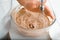 Hands of an elderly woman cook preparing cream filling for pie, housewife whipping ingredients using blender mixer