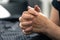 The hands of an elderly woman folded in prayer.