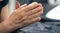 The hands of an elderly woman folded in prayer.