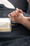 The hands of an elderly woman folded in prayer in front of a book of the Bible.