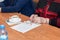 Hands of elderly woman are holding elegant steel-rimmed spectaclesa cup of tea on office table. Older people in business