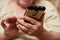 Hands of an elderly woman holding a mobile phone