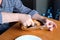 The hands of an elderly woman operate a grilled chicken