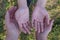 Hands of elderly woman, palms up, embrace smooth hands of young girl stretched out on other side on background of blurred grass