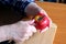 The hands of an elderly woman peel a red ripe tasty juicy apple