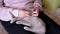 Hands of an Elderly Woman Stroking a Small Gray Kitten Sitting on Knees. Zoom