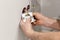 The hands of an electrician installing a wall power socket.