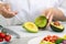 Hands emptying a fresh avocado using a spoon