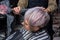 The hands of an experienced girl salon worker comb the hair of a client of an adult woman with a fashionable and stylish bob