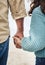 Hands, family and children with a girl and grandfather holding hands while walking outside on the beach. Kids, love and