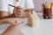 Hands of family father mother and daughther pointing to wooden house model metaphor dream for home building and decoration or