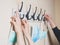 Hands of a family hanging their masks on a coat stand