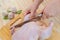 The hands of a female chef carves a whole chicken carcass on a wooden Board, the view from above. Top view