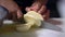 Hands of female cook slowly slicing a potato