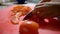 Hands of female cook slowly slicing a tomato