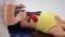 Hands of female doctor applying red and black kinesio tapes on the abdomen of young girl