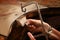 Hands of a female goldsmith work on a piece of silver with a met