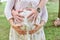 Hands of female male and baby make heart shape cute sign on bare belly of pregnant woman mother