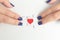 Hands of female matching red jigsaw heart halves over white background