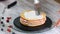 Hands of female pastry chef making delicious cake of sponge layers, whipped cream and berry jam using rotating cake