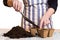 Hands filling soil into peat pots