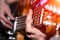 Hands and fingers of the guitarist`s bass on the fretboard