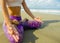 Hands and fingers posture detail of woman sitting in lotus position doing yoga and relaxation exercise outdoors at beautiful beach