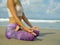 Hands and fingers posture detail of woman sitting in lotus position doing yoga and relaxation exercise outdoors at beautiful beach