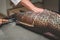 Hands of a fishmonger slicing Pintado fish