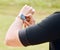 Hands, fitness and smart watch with a sports person outdoor, checking the time during a workout. Arm, exercise and