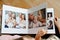 hands flip through the pages of a photo book with family photos.