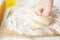 Hands in flour closeup kneading dough