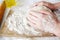 Hands in flour closeup kneading dough