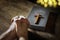 Hands folded in prayer with  Holy Bible and religious crucifix cross in church
