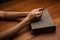 Hands folded in prayer over Holy Bible