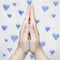 Hands folded in prayer, then with blue hearts