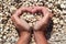 Hands in the form of heart with pebbles inside