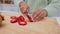 Hands, fruit and diet with a knife in the hand of a woman cutting a strawberry in the kitchen of her home. Food, health