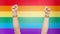 Hands with gay pride rainbow wristbands shows fist