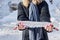 The hands of girl with a bright manicure hold a large icicle. Close-up