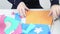 Hands of girl draws flower on colored paper and cuts for craft