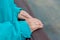 The hands of a girl dressed in a blue jacket lie on the wooden railing of the balcony. Close-up. Soft Focus